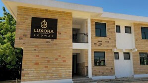 Un moderno edificio de hotel con un letrero que dice 'LUXORA Lodwar'.
