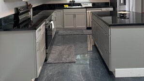 A modern kitchen with grey cabinets, stainless steel appliances, a black countertop, and a skylight above the sink. - 3BR Retreat • Private Patio • Near DC & Pentagon (Springfield)