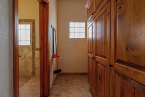 A hallway with wooden doors, a tiled floor, and a window. - Casa Evita – Beachfront, Casita, Rocky Point (Puerto Penasco)