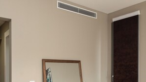 Ein Zimmer mit einem Holzkapfen, einem Spiegel und einer dunkelbraunen Tür.