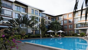 Ein Hotelinnenhof mit Swimmingpool, Liegestühlen und Sonnenschirmen.