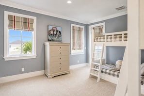 A child's bedroom with a bunk bed, a dresser, and a window with curtains. - 15 Dune Lane: Oceanfront Views Await, New Pool & Additions Coming Spring '27! (Hilton Head Island)