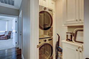 A laundry room with a washing machine, dryer, and stacked cabinets. - 15 Dune Lane: Oceanfront Views Await, New Pool & Additions Coming Spring '27! (Hilton Head Island)