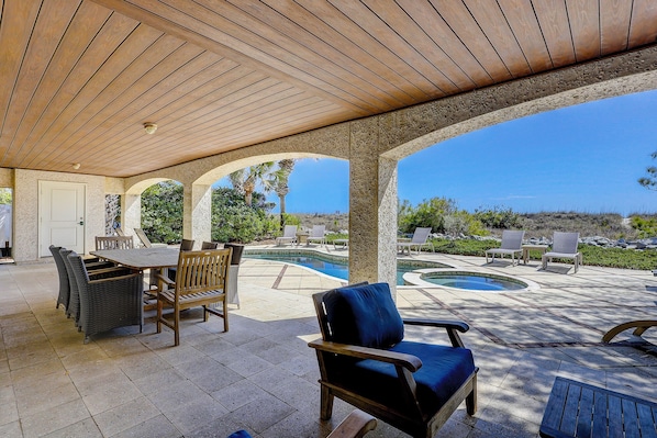 A covered patio with a pool, outdoor furniture, and a view of the landscape. - 15 Dune Lane - Oceanfront Views Await - Summer Discounts Available! (Hilton Head Island)