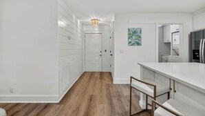 A modern kitchen with white cabinetry, a marble countertop, and a built-in oven. - Renovated Home Close to Everything! Fenced Yard, Dogs Welcome! (Saint Simons Island)