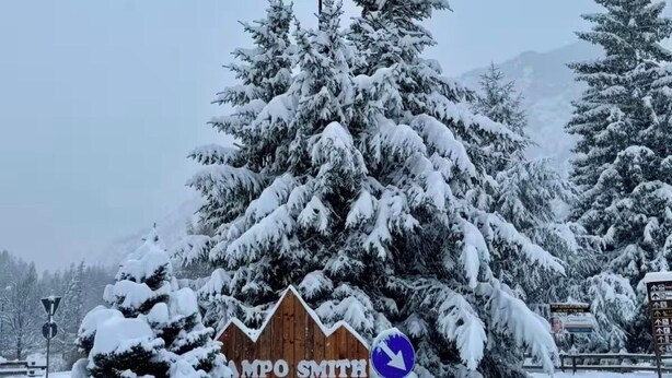 Paesaggio innevato con un cartello di legno che riporta la scritta 'AMPO SMITH' e una freccia direzionale.