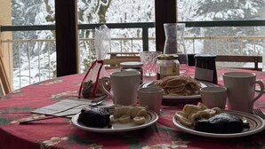 Un tavolo da pranzo con piatti di cibo, tazze e un vaso.