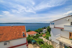 Ein Küstenwohngebiet mit Terrakotta-Dächern, weißen Gebäuden und Blick auf das Meer.