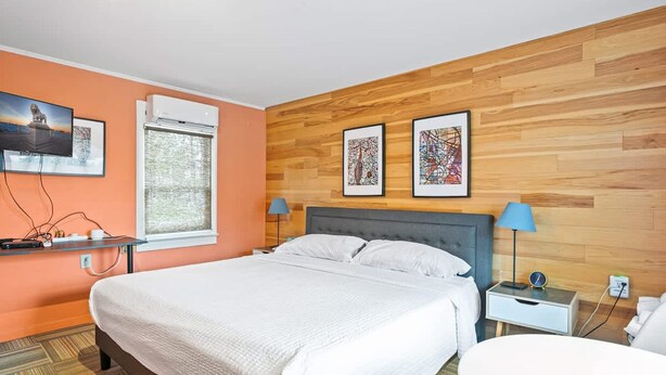A hotel room with a bed, bedside tables, a desk, and artwork on the walls. - Cozy Contemporary Space in St Augustine (St. Augustine)
