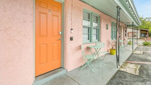 A pink building with an orange door, green shutters, and outdoor seating. - Cozy Contemporary Space in St Augustine (St. Augustine)