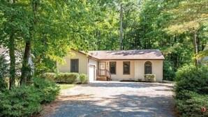 A single-story house with a front porch, a garage, and a driveway leading to the entrance. - Cozy home featuring a screened-in porch and access to a refreshing pool. Your oasis awaits!! (Ocean Pines)