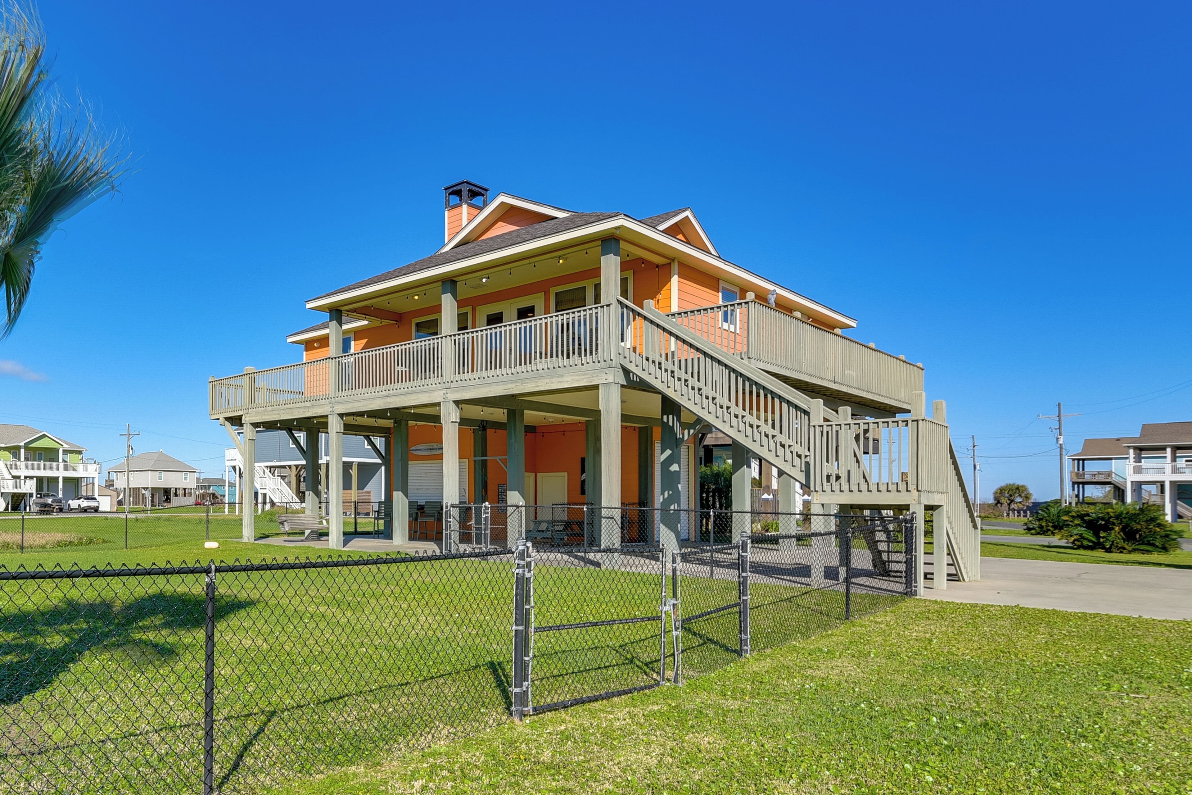 A two-story house with a balcony, a staircase, and a fenced yard.