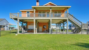 A two-story house with a balcony, a covered porch, and a staircase leading to the upper level.