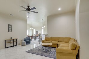 A living room with a sofa, round coffee table, and a ceiling fan. - Easy Living in Brownsville! Home Near Med Center (Brownsville)
