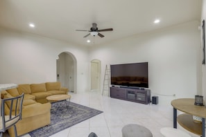 A living room with a sofa, coffee table, TV, and entertainment unit.