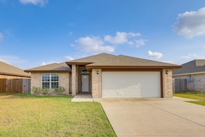 A residential house with a garage, a front door, and a small front yard.