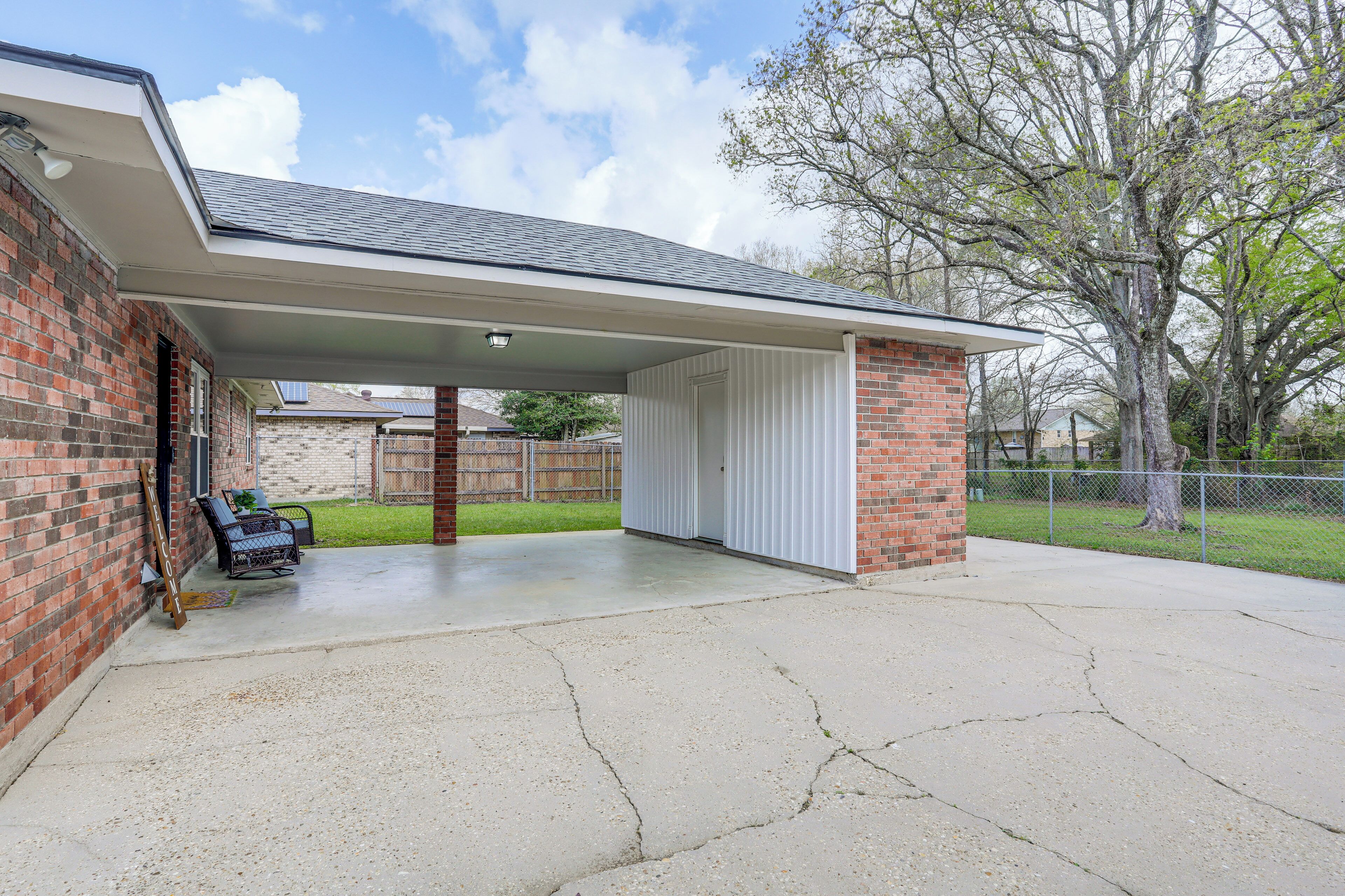 Un garage fermé avec un sol en béton, un mur en briques et une porte blanche.