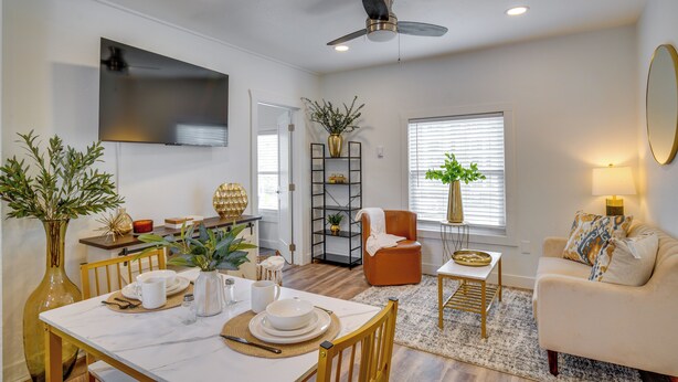 A living room with a dining area, a sofa, a TV, and a ceiling fan. - Gateway to Downtown Tacoma! Sleek Couple's Condo (Tacoma)
