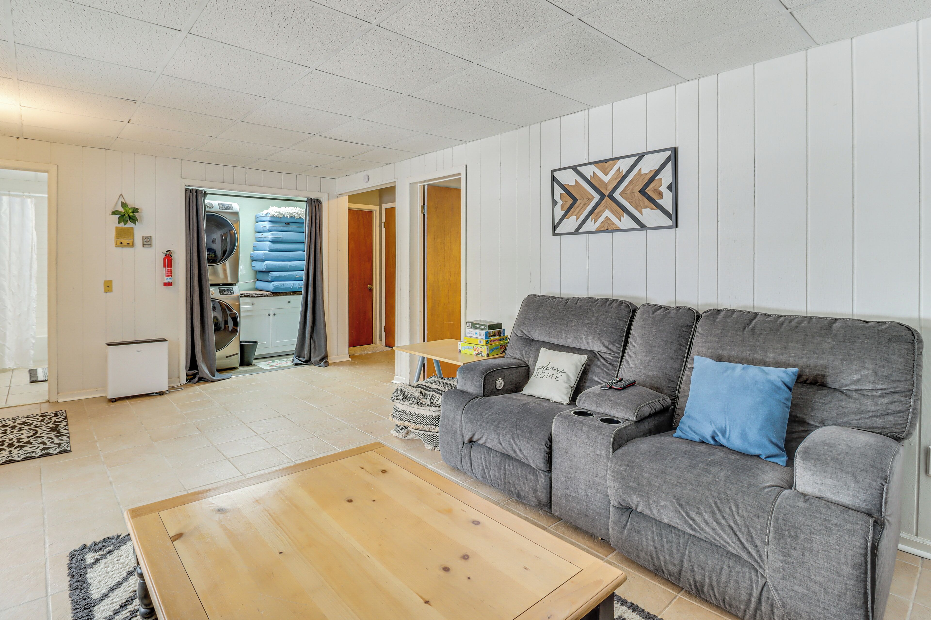 A living room with a grey sofa, a wooden coffee table, and a wall-mounted artwork.