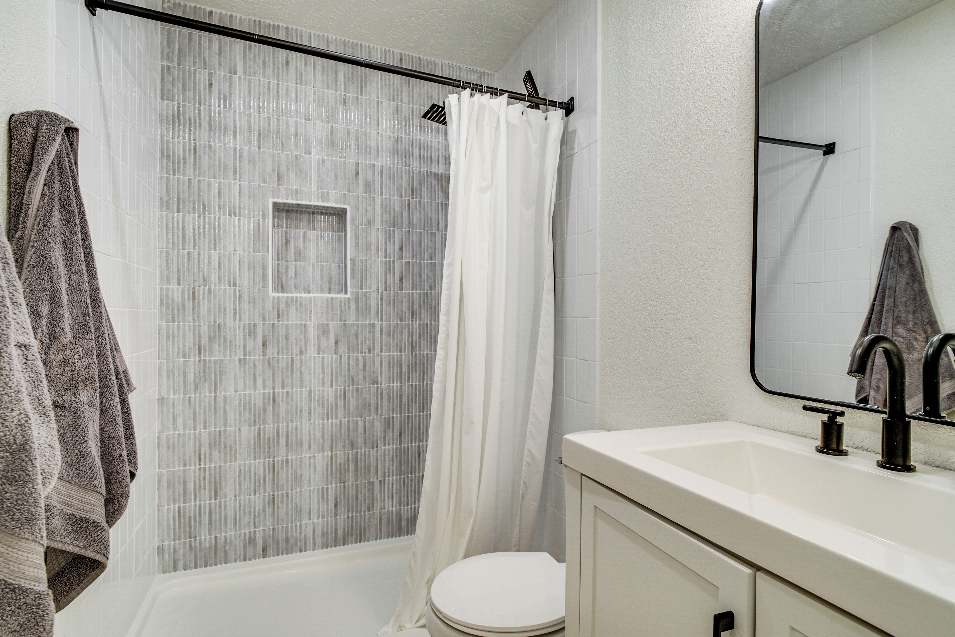 Ein Badezimmer mit Dusche, Toilette und Waschbecken.