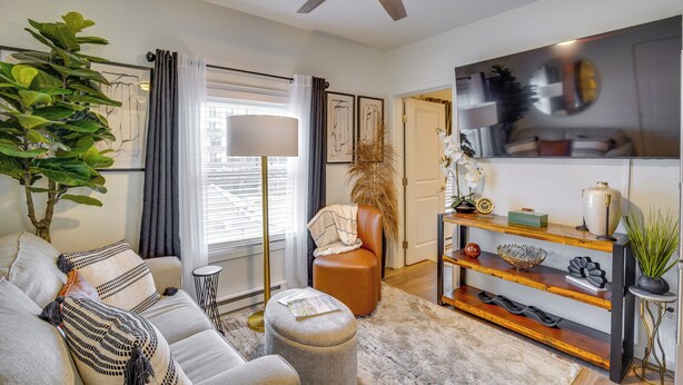 A living room with a sofa, ottoman, floor lamp, and a ceiling fan. - Easy Access to Dtwn Tacoma! Stylish Couple's Condo (Tacoma)