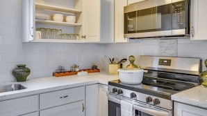 A kitchen with white cabinets, a stainless steel stove, and a microwave. - Easy Access to Dtwn Tacoma! Stylish Couple's Condo (Tacoma)