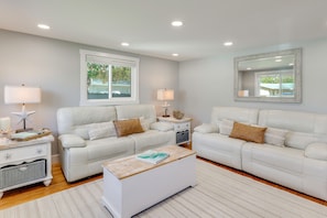 A modern living room with two white leather sofas, a wooden coffee table, and a white side table with lamps. - 7 Mi to Indian Rocks Beach: Breezy Family Retreat! (Largo)