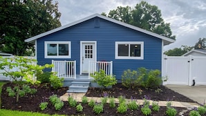 A blue house with a white front door, two windows, a small porch, and a garden with various plants. - 7 Mi to Indian Rocks Beach: Breezy Family Retreat! (Largo)