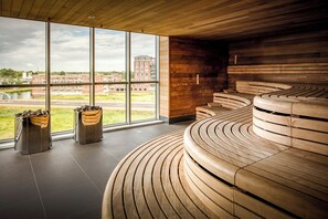 Un intérieur moderne avec de grandes fenêtres, un banc en bois aux lignes courbes et une vue sur un immeuble situé de l’autre côté de la rue.