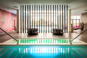 An indoor swimming pool with a view through a bamboo screen, a red door, and a hammock with flowers. - Always a Great Idea To Unwind! Free Breakfast, Swimming Pool, Nearby Trails! (Helmond)