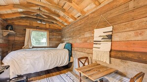 A wooden cabin room with a bed, a table, and a chair. - 5 Mi to Mt Rainier Park: Unique & Rustic Getaway (Ashford)