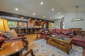 A spacious living area with a large sofa, a coffee table, and a dining area with chairs and a table. - 4BR Home w/ 2 Decks, Near Lake & Ski Resorts (Truckee)