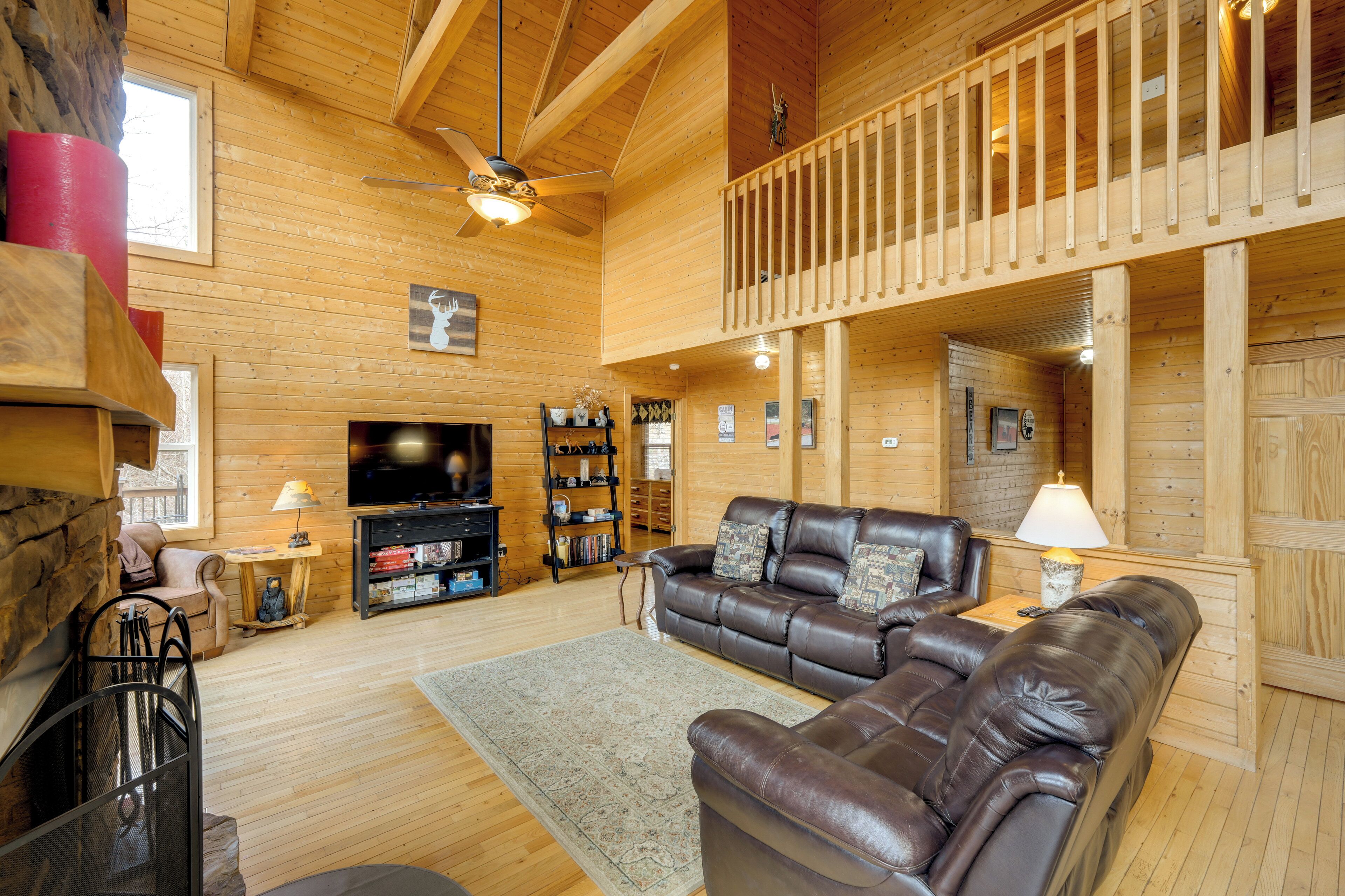 A wooden interior with a leather sofa, a television, and a bookshelf.