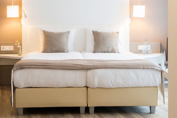 Unwind in crisp linens beneath soft, calming bedside glow.