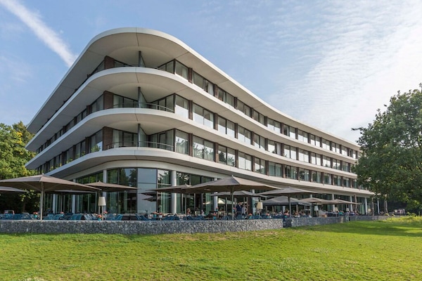 Arrive to sleek modern architecture framed by peaceful greenery.