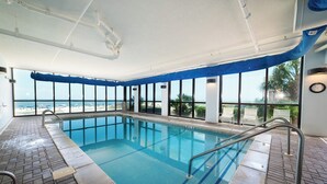 An indoor swimming pool with clear views of the beach and palm trees. - Summerchase 305 by Liquid Life (Orange Beach)
