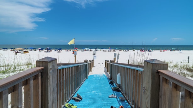 A wooden boardwalk leading to a beach with umbrellas and beachgoers. - Summerchase 305 by Liquid Life (Orange Beach)