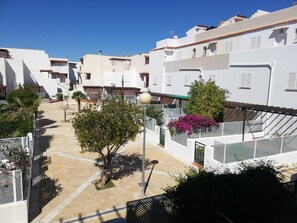 A residential area with white buildings, a paved courtyard, and a street lamp. - Apartment in Almeria With Shared Pool (Vera)