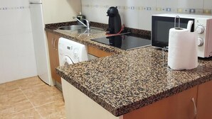 A compact kitchen with a microwave, toaster, kettle, and a paper towel dispenser. - Seaside Apartment in Vera With Terrace (Vera)