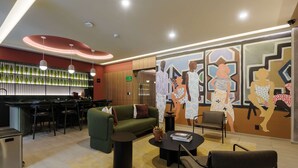 A modern hotel lobby with a reception desk, bar area, seating, and a mural. - w Tasteful 1BR w Private Balcony in Tabacalera (Mexico City)