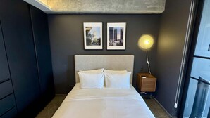 A hotel room with a bed, a nightstand, a lamp, and two framed pictures on the wall. - w Tasteful 1BR w Private Balcony in Tabacalera (Mexico City)