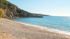 A pebble beach with a rocky cliff and clear blue sea. - Villa Alexia - Private Pool Panoramic Sea Views (Samos)