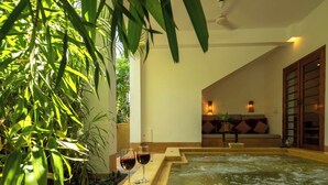Et spa-område med jacuzzi, siddepladser og planter.