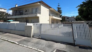 A two-story building with a flat roof, a gated entrance, and a clear blue sky. - Le Chic Azuréen (Villeneuve-Loubet)