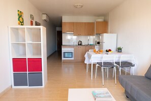 A compact living space with a kitchenette, dining area, and a sofa. - Vacation Apartment in Roquetas de Mar (Roquetas de Mar)