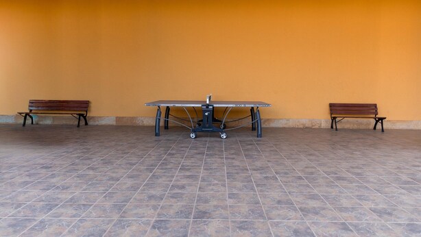 A room with a ping pong table, two benches, and a tiled floor. - Vacation Apartment in Roquetas de Mar (Roquetas de Mar)