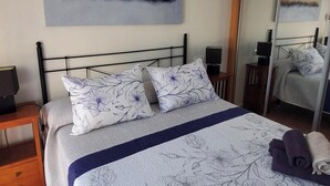 A bedroom with a bed, a ceiling fan, a nightstand, a mirror, and a painting on the wall. - Cozy Apartment in Vera, Just Steps From the Beach (Vera)