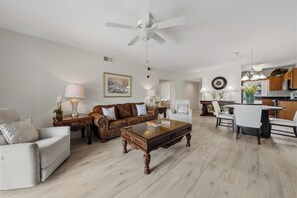 A living room with a sofa, armchair, coffee table, and dining area with a table and chairs. - Three Bedroom Two Bathroom Condo in Pigeon Forge| Near Dollywood| Sleeps 8 (Pigeon Forge)