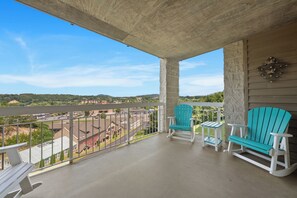 A balcony with two Adirondack chairs, a view of a road, and a distant landscape. - Three Bedroom Two Bathroom Condo in Pigeon Forge| Near Dollywood| Sleeps 8 (Pigeon Forge)