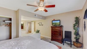 A bedroom with a bed, a dresser, a television, and a ceiling fan. - Two bedroom, two bath condo| Near the Old Mill District| Dollywood| Sleeps 6 (Pigeon Forge)